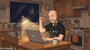 Dad celebrates late-night app win at kitchen table, wearing AiSD shirt, laptop open, coffee mug in hand—real-life parenting meets smart tech.